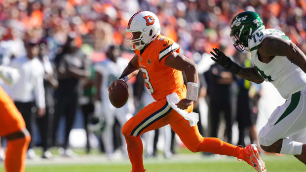 Broncos' QB Russell Wilson runs away from pressure by the Jets' defense